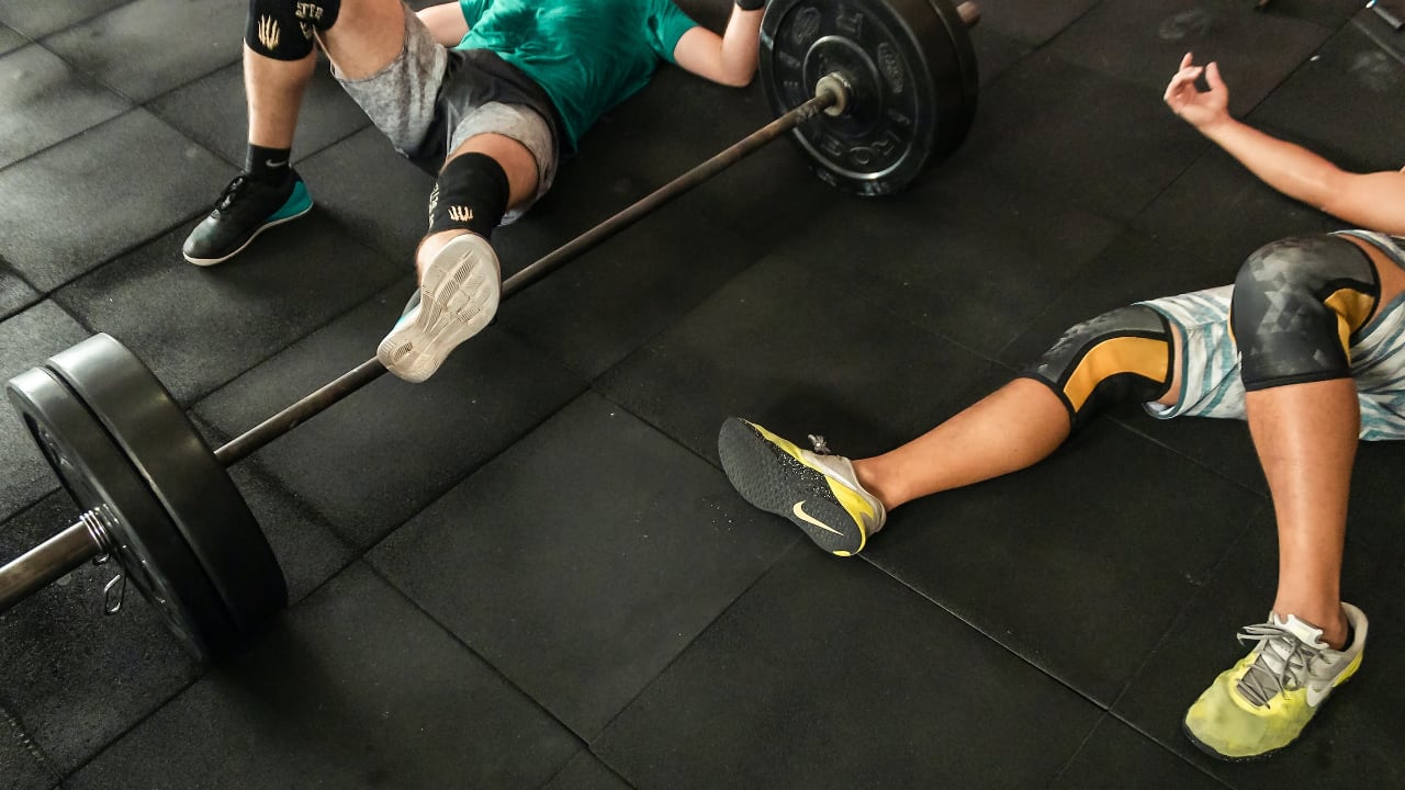 Athletes wearing knee sleeves, resting after a CrossFit WOD